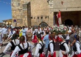 La imagen de San Lorenzo portada en procesión y rodeada del grupo de bailes "El Espinero" en Saucelle