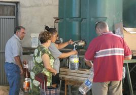 Varios vecinos de Cantalpino recogen agua de los depósitos de Diputación en el almacén municipal.