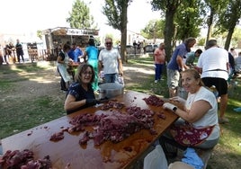 Vecinos de Villoria preparan la carne para la merienda de la vaca