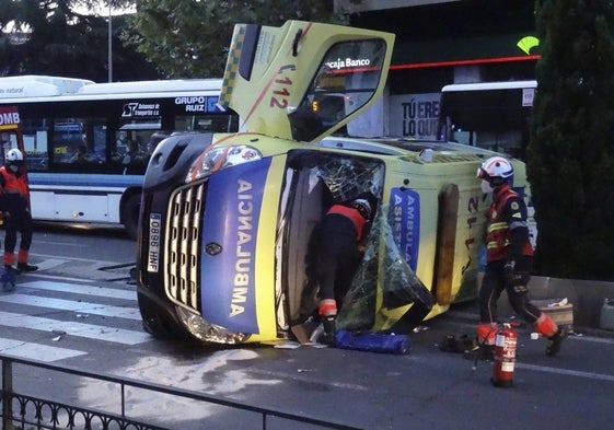 Los Bomberos trabajan en el lugar tras el vuelco de la ambulancia.