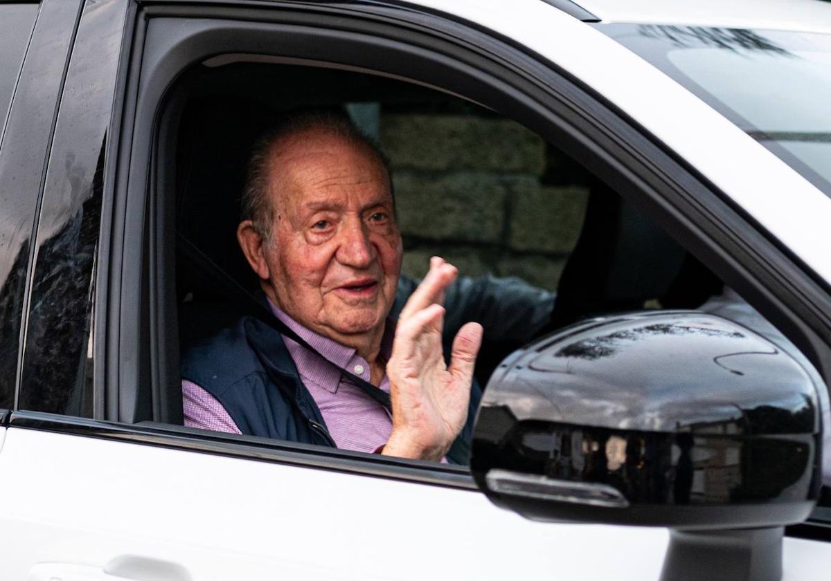 El rey Juan Carlos saluda a su salida en coche de casa de Pedro Campos.