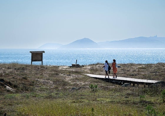 Dos personas se dirigen a la playa Silgar, en Galicia, a finales de septiembre.