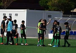 La delegada del cadete del Jai Alai, repartiendo el DNI a sus jugadores en pleno campo tras validar fichas.
