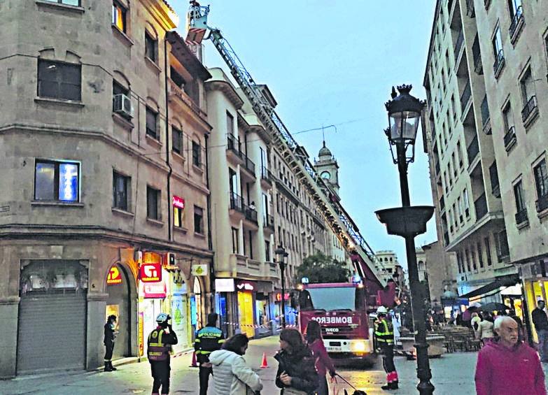 Los bomberos asegurando una antena, en la calle Zamora.