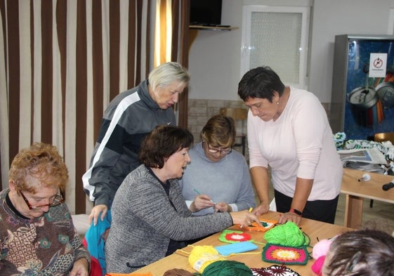 Mujeres de Cordovilla reunidas en el local del bar municipal confeccionan el árbol.
