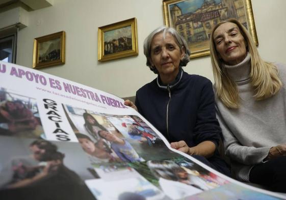 Ana Santero y su hermana María Ángeles sostienen uno de los carteles con los que piden apoyo a la sociedad salmantina.