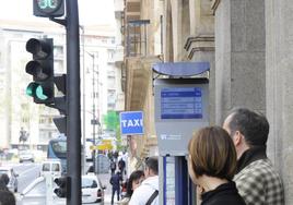 Usuarios del servicio municipal de autobús esperan la llegada del bus de su línea en la parada de la Gran Vía.