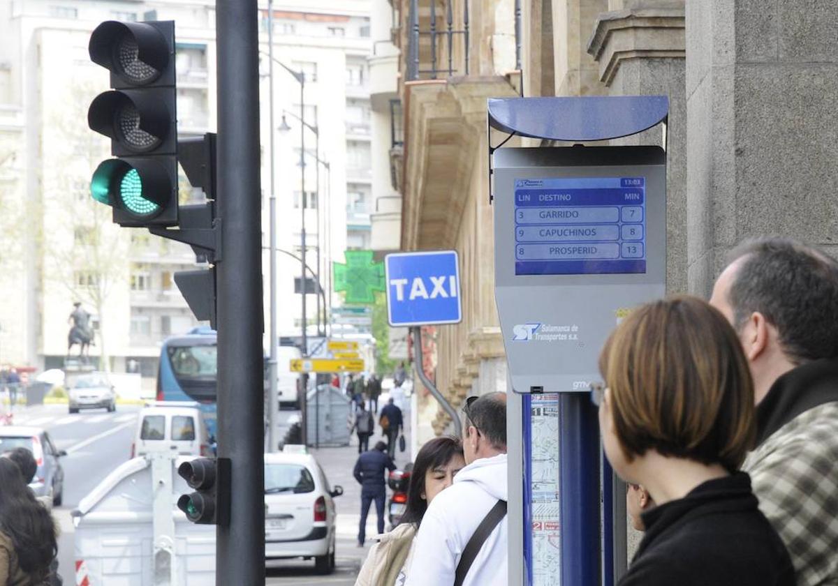 Usuarios del servicio municipal de autobús esperan la llegada del bus de su línea en la parada de la Gran Vía.