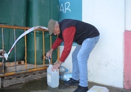 Un vecino de Vitigudino llena garrafas de agua de los depósitos junto al silo.