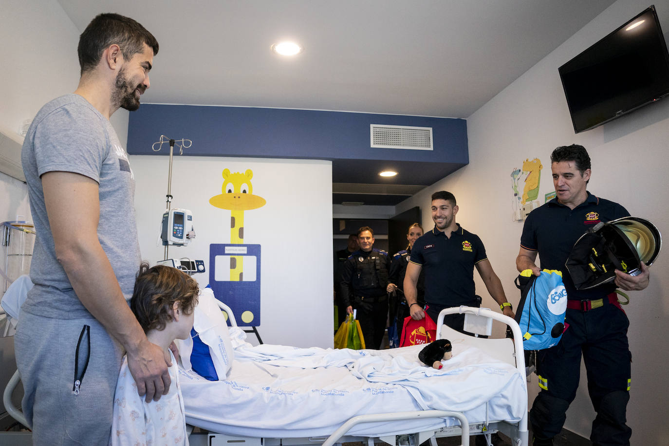 Bomberos y agentes reparten y regalos a los niños hospitalizados en el Puerta de Hierro