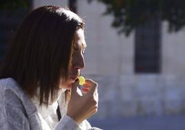 Una mujer a punto de comer una uva.