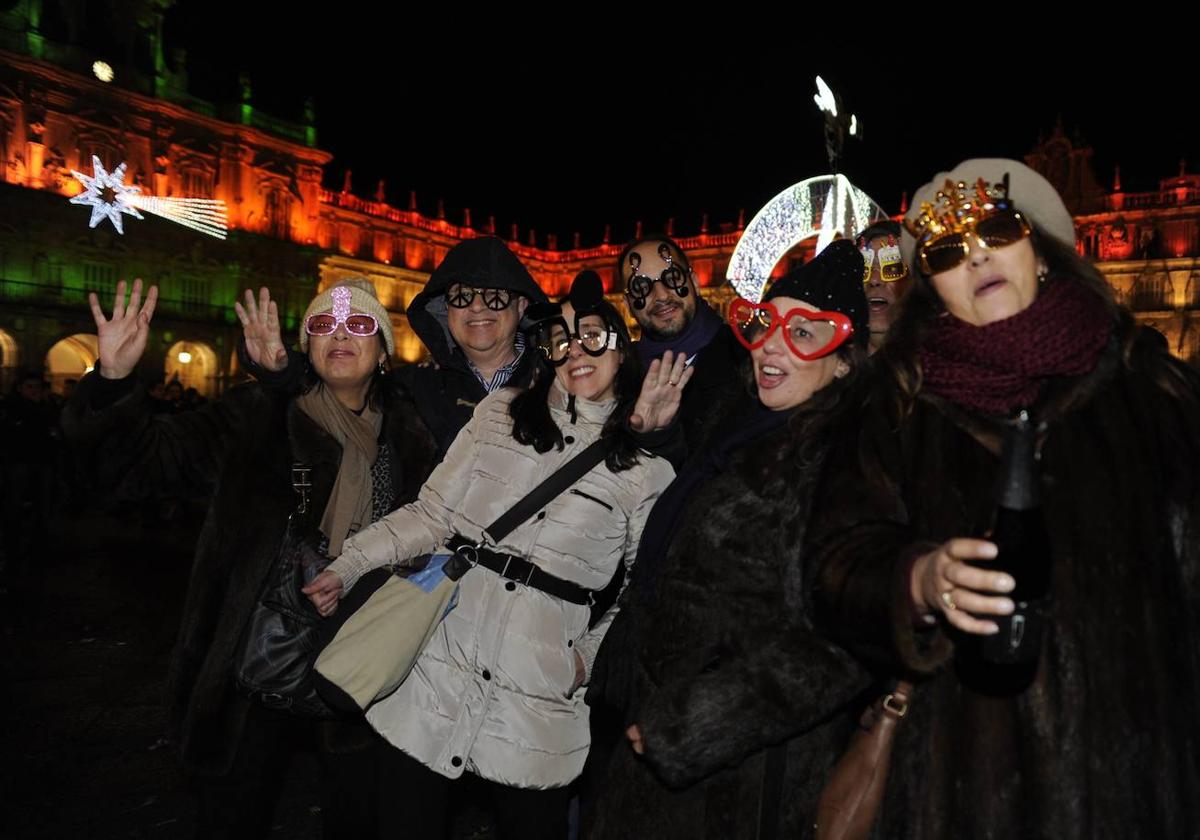 Un grupo de personas «brinda» por la llegada del año 2014 tras unas accidentadas campanadas en la Plaza Mayor de Salamanca.