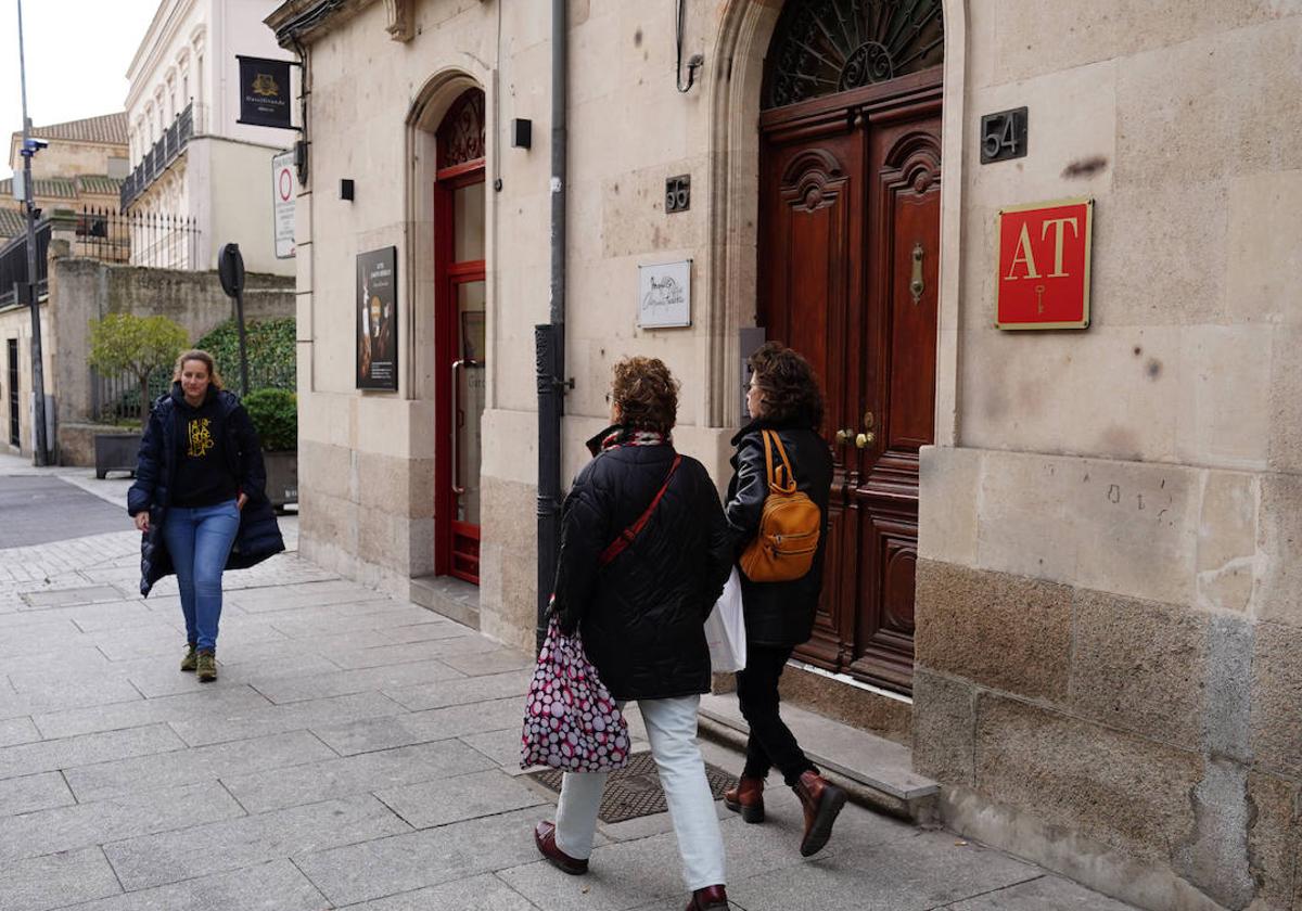 Dos viandantes pasan junto al acceso de un céntrico apartamento turístico.