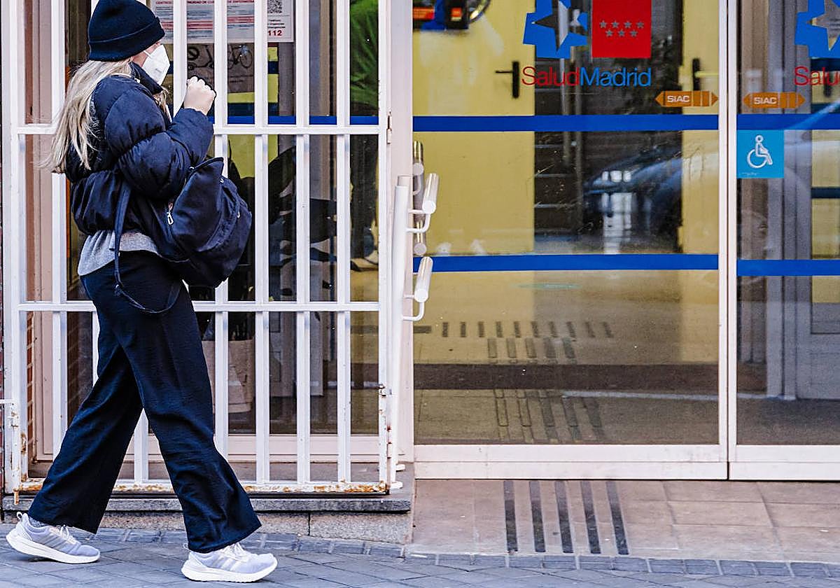 Una mujer pasa con mascarilla por el centro de salud madrileño