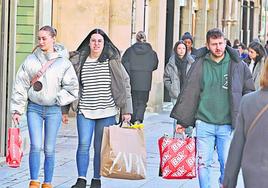 Salmantinos con bolsas tras realizar compras en las tiendas del centro de la ciudad.