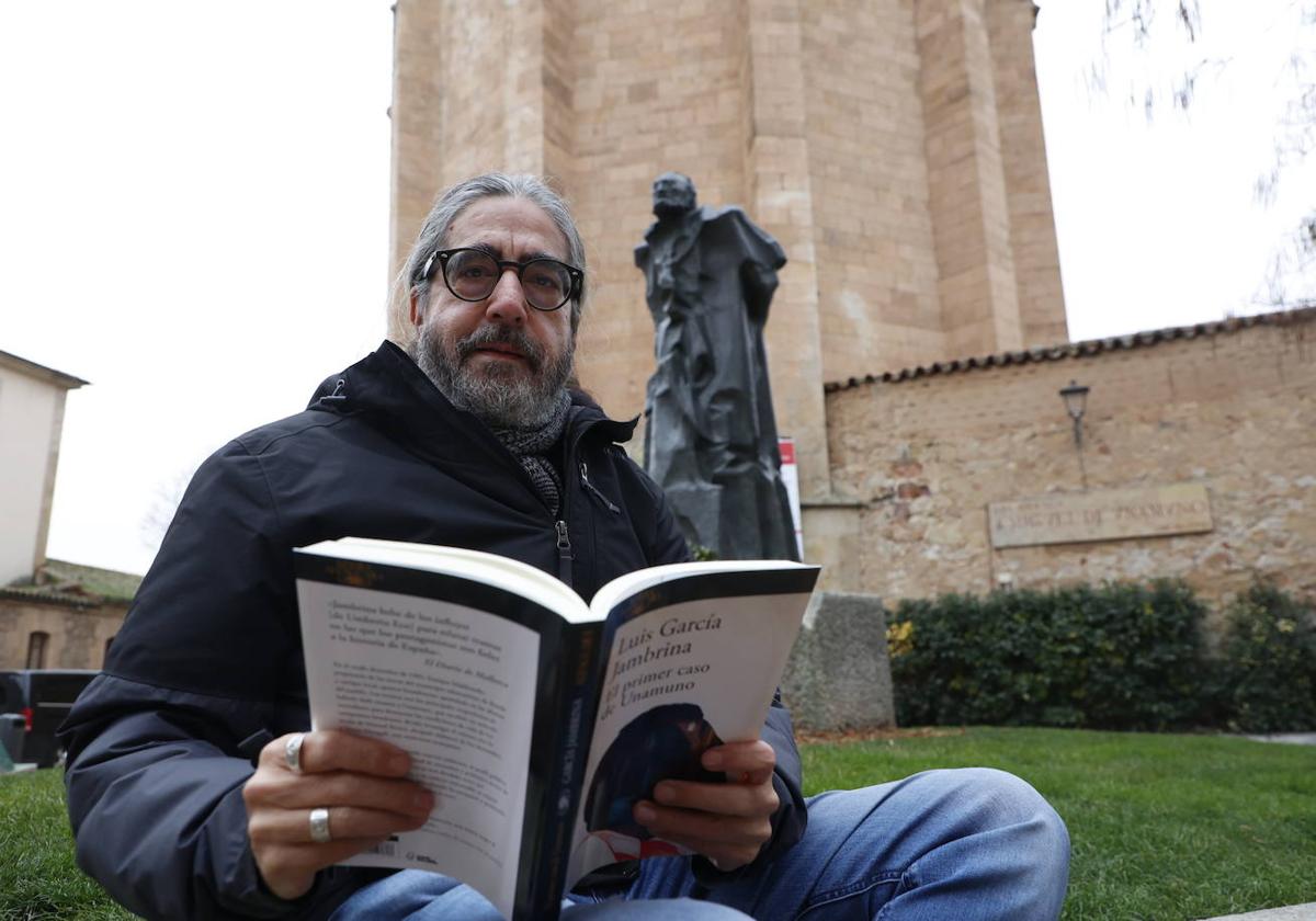 Luis García Jambrina con un ejemplar de su último libro con la estatua de Unamuno detrás.