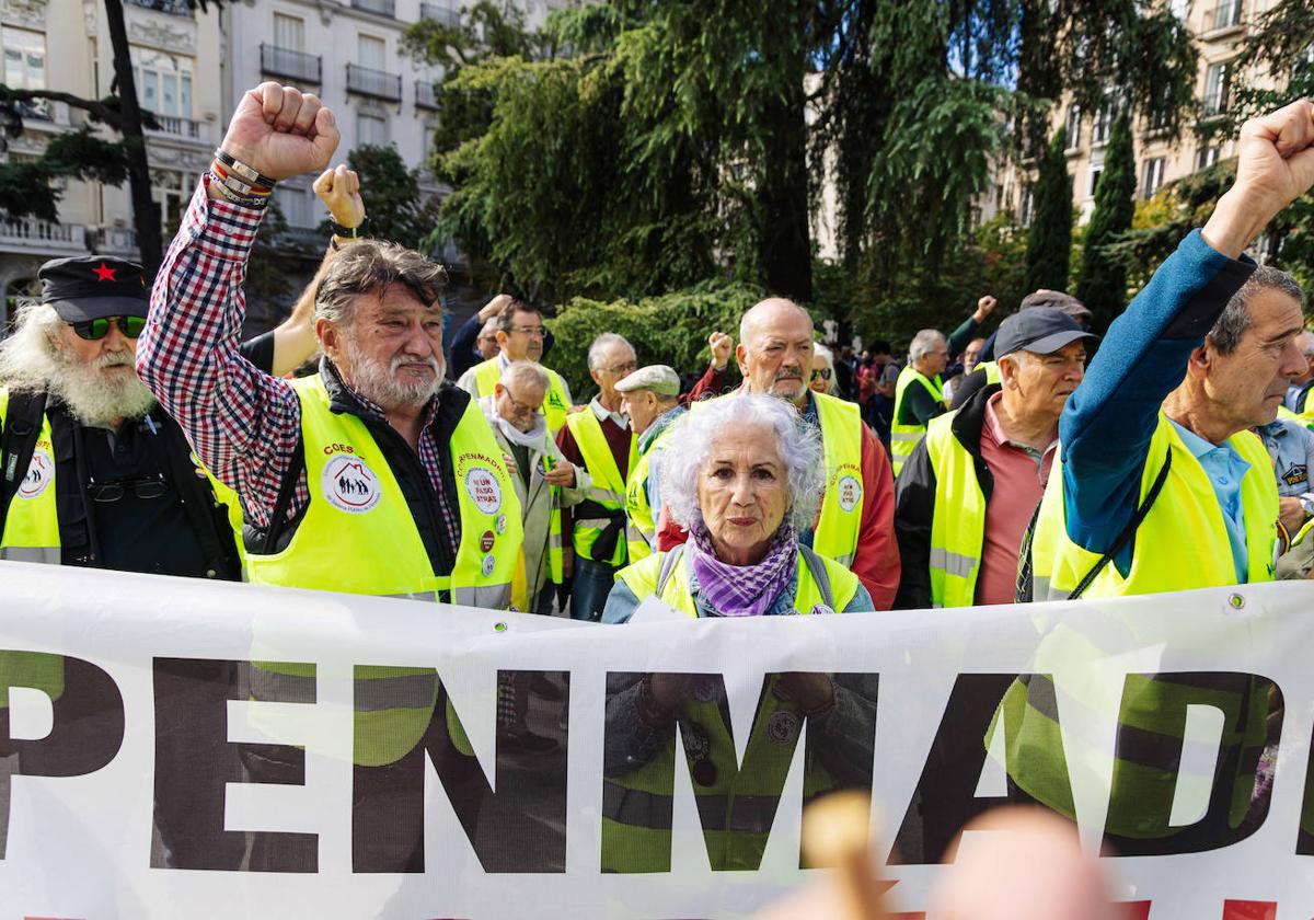 Varios pensionistas con una pancarta durante una manifestación frente al Congreso de los Diputados, a 18 de octubre de 2023