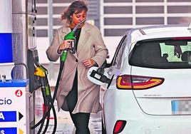 Una conductora repostando carburante en una estación de servicio.