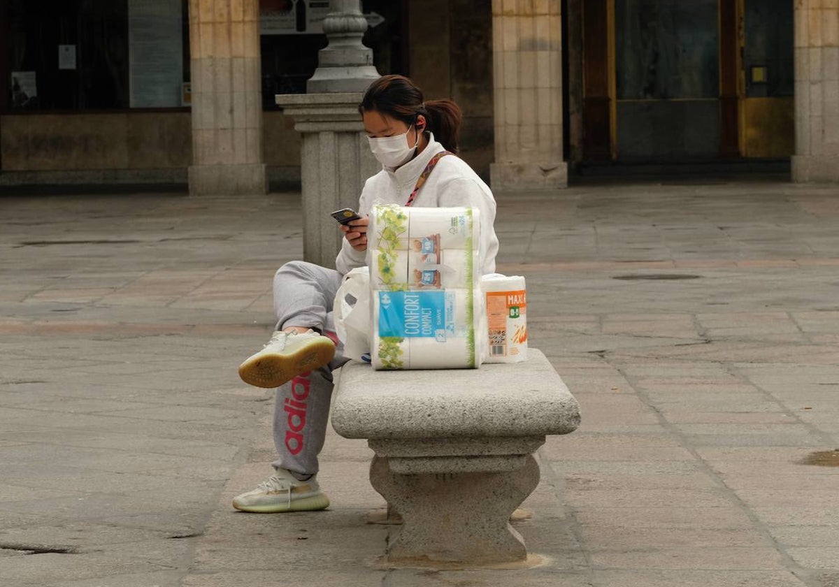 Una mujer con una bolsa de papel higiénico en Salamanca.