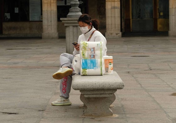 Una mujer con una bolsa de papel higiénico en Salamanca.