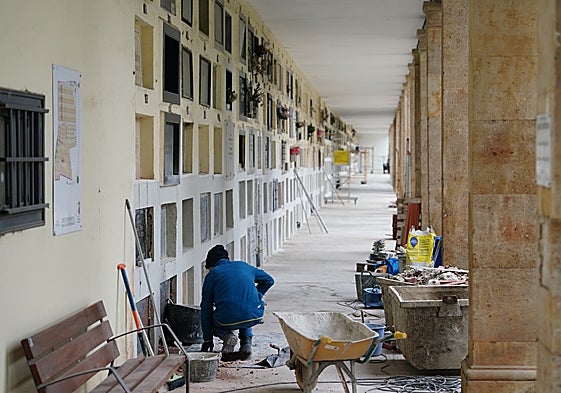 Un obrero reparando los nichos del cementerio.