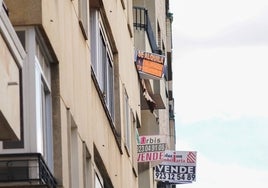 Varios carteles de venta y alquiler de pisos en un edificio de Salamanca.