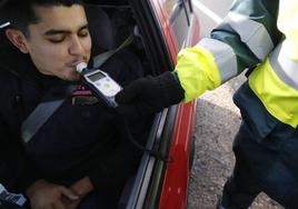 Un conductor sopla en un alcoholímetro en la realización de una prueba de la Guardia Civil de Tráfico.