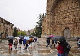 Gente resguardándose de la lluvia con paraguas en la plaza del Concilio de Trento