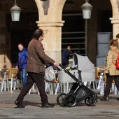 Un hombre empuja un carro de bebé por la Plaza Mayor.