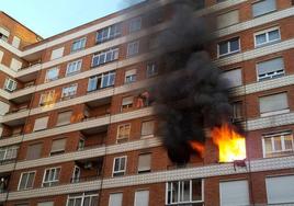 Dos vecinos intentan escapar de las intensas llamas declaradas en la tercera planta del edificio tras salir a través de un balcón en 2016.