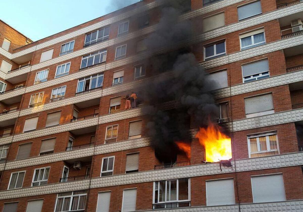 Dos vecinos intentan escapar de las intensas llamas declaradas en la tercera planta del edificio tras salir a través de un balcón en 2016.