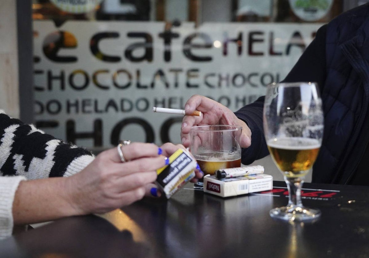 Dos personas fuman en la terraza de un bar de Salamanca.