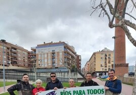 Los protagonistas de la limpieza de este sábado, con la basura recogida a lo largo del río.