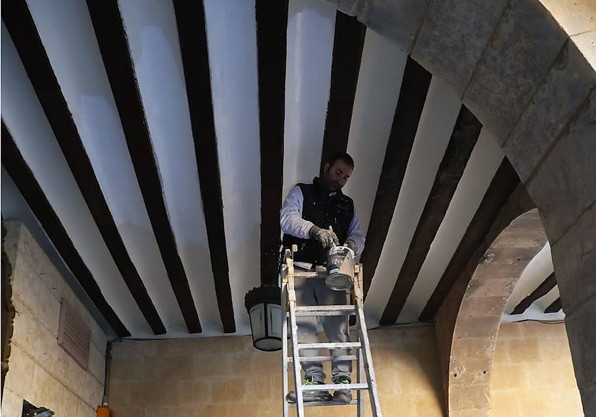 El pintor remata la zona afectada por la filtración, junto al arco de la calle Toro.