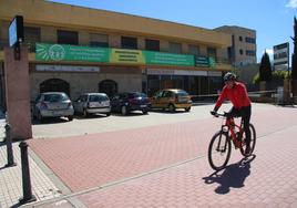 Un ciclista pasa por delante del edificio adquirido por ASPACE para su centro de día y dos viviendas.