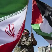 Iraní con una bandera de Irán y otra Palestina.