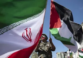 Iraní con una bandera de Irán y otra Palestina.