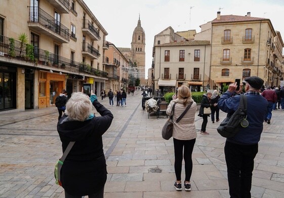Turistas hacen fotos a la Catedral desde la Rúa Mayor.