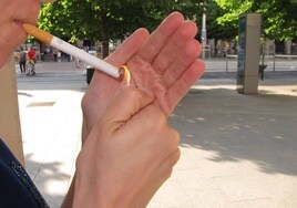 Una persona se enciende un cigarro