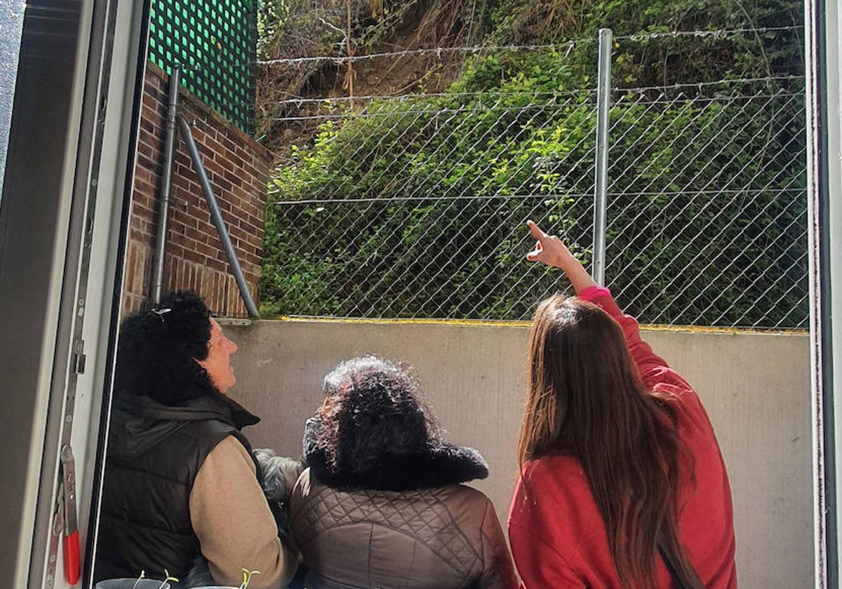 Tres vecinas de los edificios 9 y 11 de la calle Arco del Monte contemplando la parte del terraplén desprendida la semana pasada.