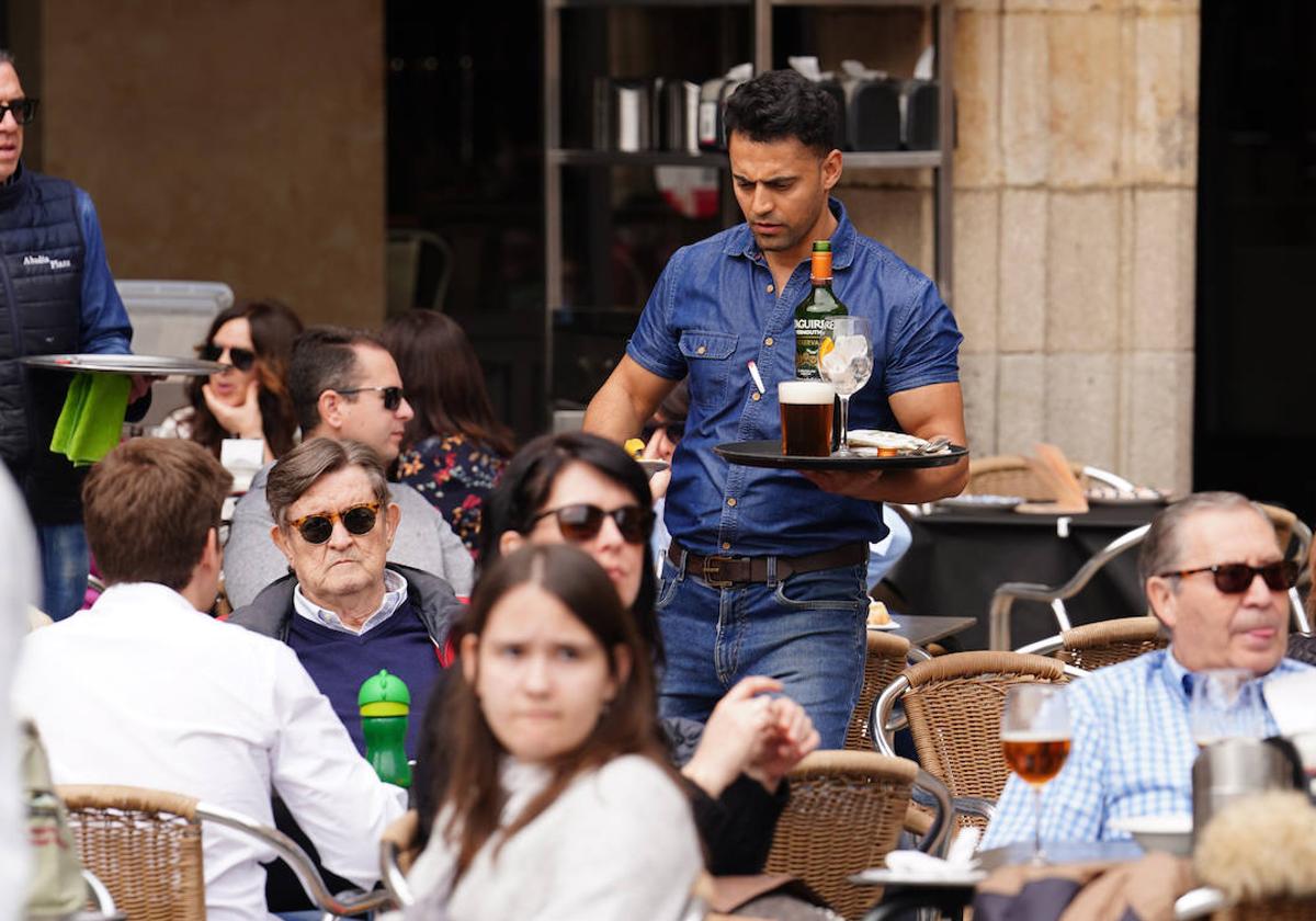 Un camarero atendiendo las mesas de una terraza de la Plaza Mayor.