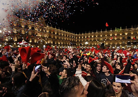 Jóvenes con móviles durante la Nochevieja Universitaria del año 2018 en la Plaza Mayor.