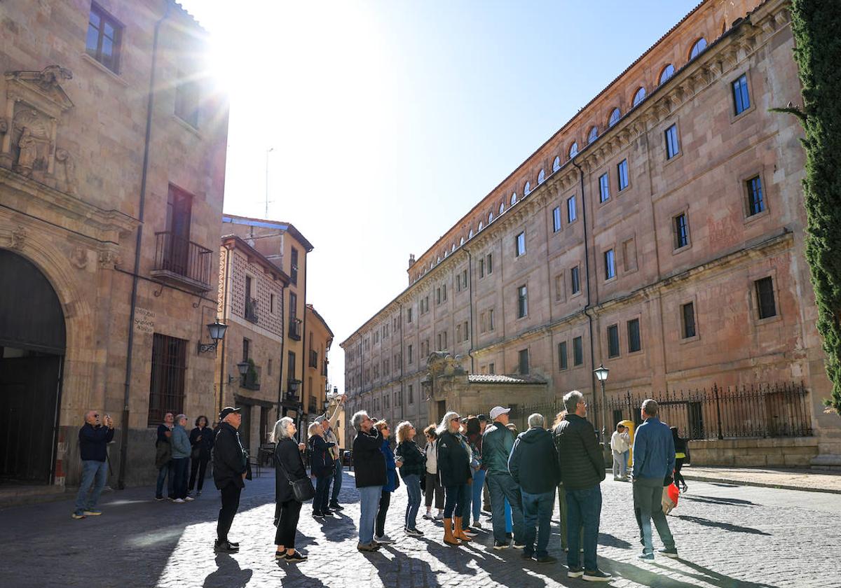 Varios turistas disfrutan del sol en una calle céntrica.