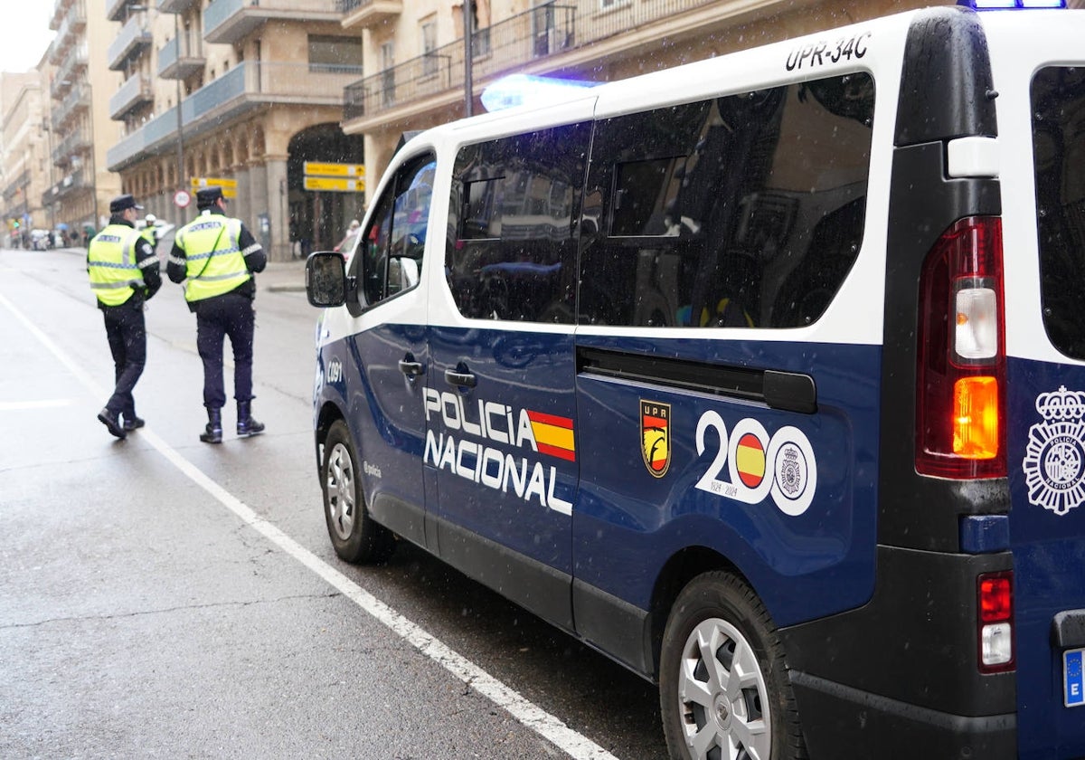 Agentes de la Policía Nacional, junto a uno de sus vehículos, en plena Gran Vía.