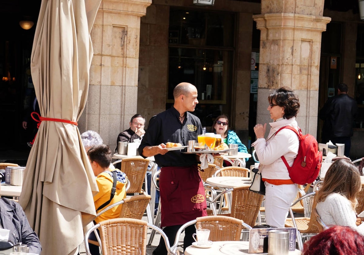 Un camarero de la Plaza Mayor atiende a una clienta.