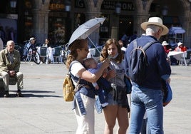 Una familia disfrutando del sol en la Plaza Mayor.