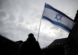 Un joven porta la bandera de Israel.
