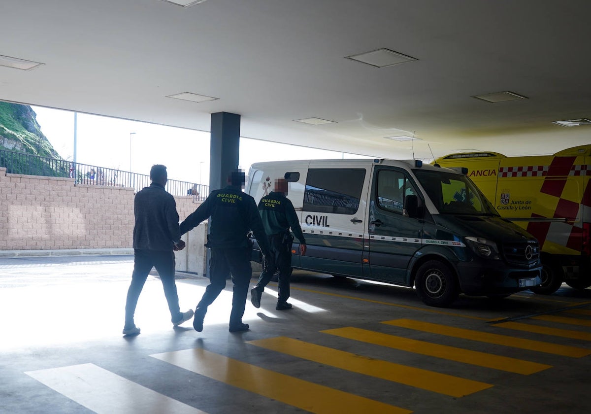 Dos agentes de la Guardia Civil trasladan a un preso al furgón desde las Urgencias.