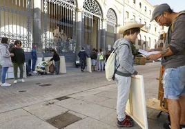 Un padre, junto a su hijo, a las puertas del Palacio de la Salina, donde se han congregado decenas de artistas.