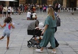 Una pareja de Salamanca pasea con un carrito de bebé.